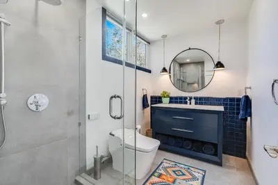 a bathroom with a toilet and a sink and a mirror at Luxury Beachfront Townhouse with Breathtaking Views in Solana Beach