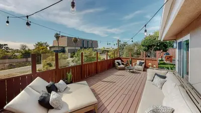 a balcony with white couches on a wooden deck at The Clubhouse by Coastline Vacation Rentals in San Diego