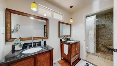 a bathroom with a sink and a large mirror at The Clubhouse by Coastline Vacation Rentals in San Diego