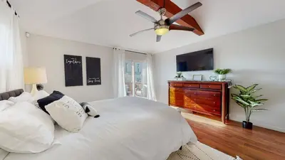 a bedroom with a bed and a ceiling fan at The Clubhouse by Coastline Vacation Rentals in San Diego