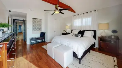 a bedroom with a white bed and a kitchen at The Clubhouse by Coastline Vacation Rentals in San Diego