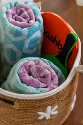 a basket filled with towels on top of a table at The Surf Shack by Coastline Vacation Rentals in San Diego