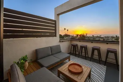 a balcony with a couch and a bar with a view at Nomad Surf Lounge by Coastline Vacation Rentals in San Diego