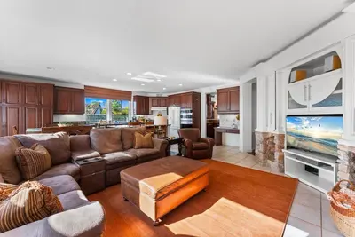 a large living room with a couch and a kitchen at Carmel Valley Villa by Coastline Vacation Rentals in San Diego