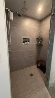 a bathroom with a shower with a tiled wall at Little Italy, close to everything in San Diego