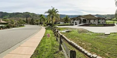 a street with houses and a road with a fence at Beautiful Villa with Amazing 360 Mountain Views, Golfcourses close to Monserate Winery and I-15 in Fallbrook