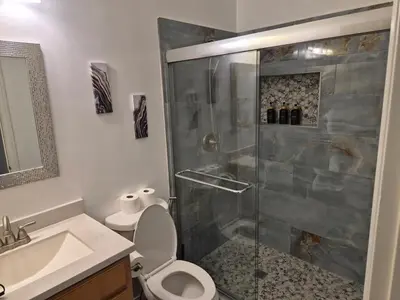 a bathroom with a shower with a toilet and a sink at Amazing Guest House near Monserate Winery with 360 Mountain Views in Fallbrook