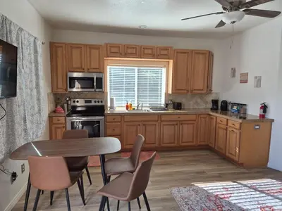 a kitchen with wooden cabinets and a table and chairs at Amazing Guest House near Monserate Winery with 360 Mountain Views in Fallbrook