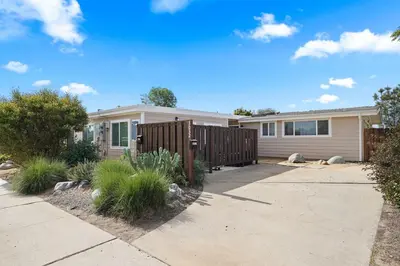 a house with a fence in front of it at The Oasis by Coastline Vacation Rentals in San Diego