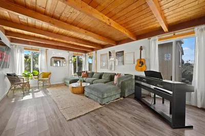 a living room with a couch and a piano at The Oasis by Coastline Vacation Rentals in San Diego