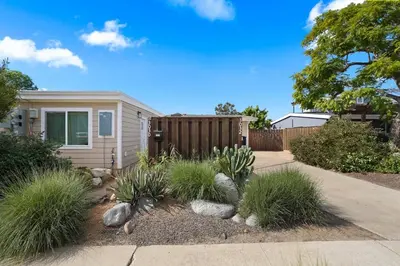 a house with a fence and some plants in the yard at The Oasis by Coastline Vacation Rentals in San Diego