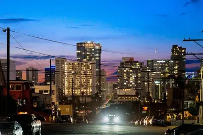 a city at night with cars driving down a street at La Dolce Vita by Coastline Vacation Rentals in San Diego