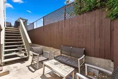 a patio with two chairs and a table and a fence at La Dolce Vita by Coastline Vacation Rentals in San Diego