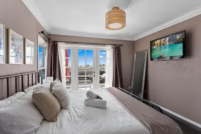 a bedroom with a large white bed with a window at La Dolce Vita by Coastline Vacation Rentals in San Diego