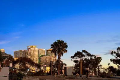a city skyline with a palm tree and buildings at La Dolce Vita by Coastline Vacation Rentals in San Diego