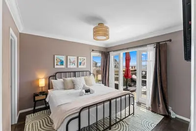 a bedroom with a large bed and a balcony at La Dolce Vita by Coastline Vacation Rentals in San Diego