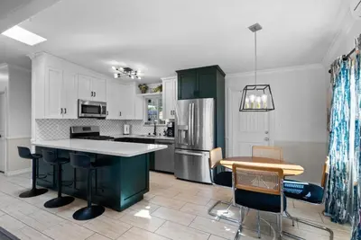a kitchen with white cabinets and a green island at The Lookout by Coastline Vacation Rentals in Chula Vista