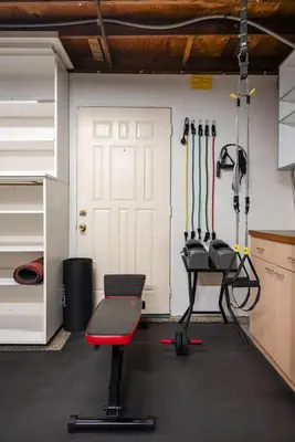 a garage with a gym with a bench and a door at The Lookout by Coastline Vacation Rentals in Chula Vista