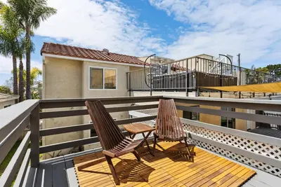 a balcony with two chairs and a playground at Bohemian Seaside by Coastline Vacation Rentals in San Diego