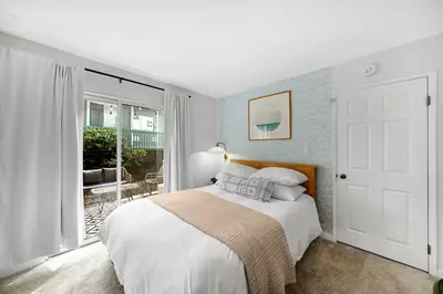 a white bedroom with a bed and a sliding glass door at Athena FULL Property in Encinitas