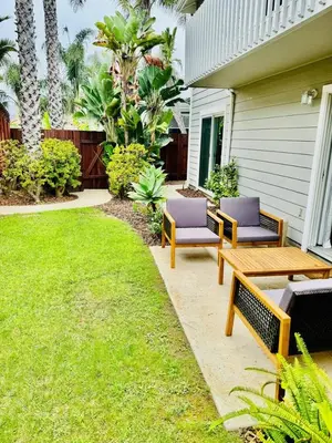 a patio with two benches and a grass yard at Athena FULL Property in Encinitas