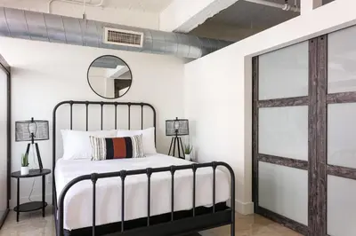 a bedroom with a bed and a mirror at SD Modern Rustic 3BR Apartment in San Diego