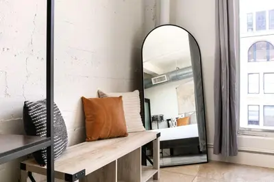 a mirror in a room with a bench and a bed at SD Modern Rustic 3BR Apartment in San Diego