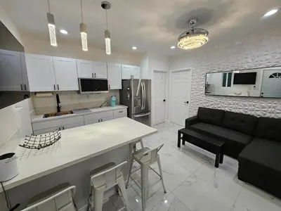 a kitchen and living room with a black couch at Modern Marble Retreat Private Gated ADU with Laundry & Parking in National City