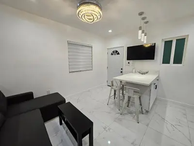 a white living room with a table and a couch at Modern Marble Retreat Private Gated ADU with Laundry & Parking in National City