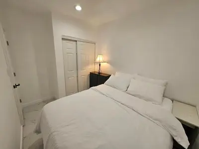 a white bed in a white bedroom with a lamp at Modern Marble Retreat Private Gated ADU with Laundry & Parking in National City