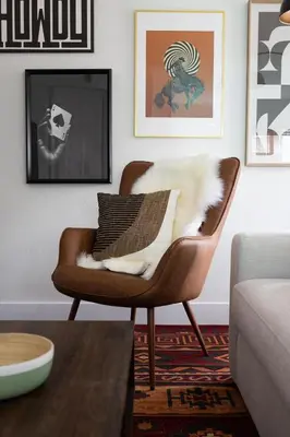 a brown chair sitting in a living room with a table at The Outpost by Coastline Vacation Rentals in San Diego
