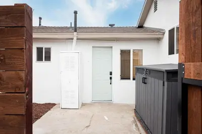 a white house with white doors and a driveway at The Outpost by Coastline Vacation Rentals in San Diego