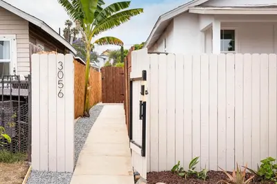 a white fence next to a house at The Outpost by Coastline Vacation Rentals in San Diego