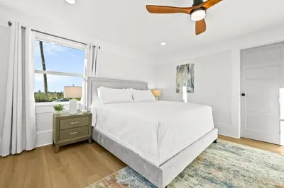 a white bedroom with a bed and a window at Vista Voltaire by Coastline Vacation Rentals in San Diego