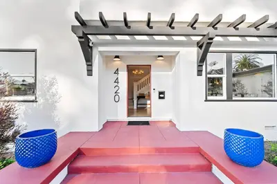 a white house with red steps and blue pots at Vista Voltaire by Coastline Vacation Rentals in San Diego