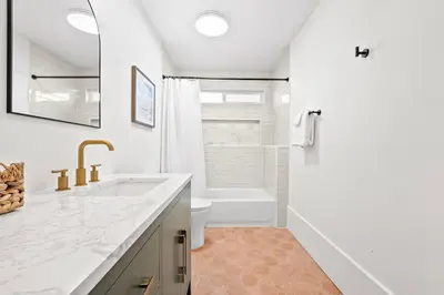 a white bathroom with a sink and a toilet at Vista Voltaire by Coastline Vacation Rentals in San Diego
