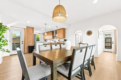 a kitchen and dining room with a wooden table and chairs at Vista Voltaire by Coastline Vacation Rentals in San Diego