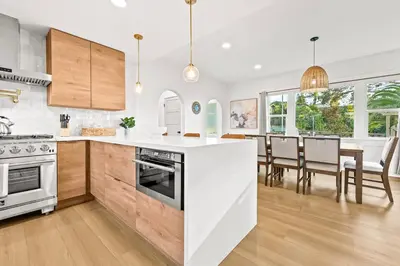 a kitchen with white countertops and a dining room at Vista Voltaire by Coastline Vacation Rentals in San Diego