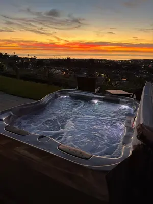 a jacuzzi tub with a sunset in the background at Avenida Paradise! in San Clemente