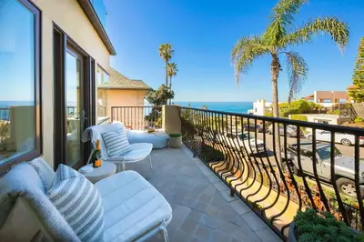 a balcony with white furniture and a view of the ocean at Sea & Sand - Ocean View La Jolla Condo in San Diego