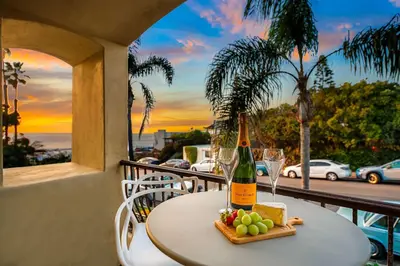 a table with a bottle of wine and a plate of fruit at Sea & Sand - Ocean View La Jolla Condo in San Diego