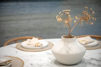 a white vase with a flower in it on a table at Sea & Sand - Ocean View La Jolla Condo in San Diego