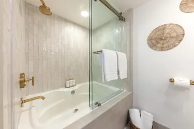 a bathroom with a tub and a glass shower at Sea & Sand - Ocean View La Jolla Condo in San Diego