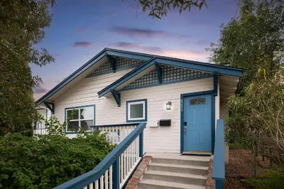 a white house with a blue door and stairs at Close to Balboa Park Central Villa in San Diego