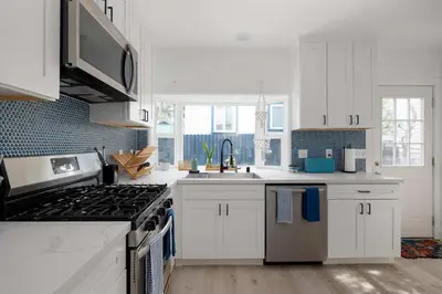 a kitchen with white cabinets and a stove top oven at Close to Balboa Park Central Villa in San Diego