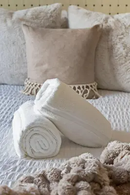 a white towel sitting on top of a bed at The Ruby Door by Coastline Vacation Rentals in San Diego