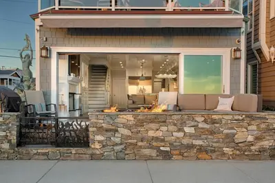 a house with a stone wall with a fire pit at Newport Beach Oceanfront Home in Newport Beach