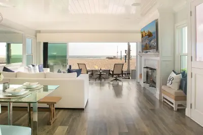 a living room with a white couch and a fireplace at Newport Beach Oceanfront Home in Newport Beach