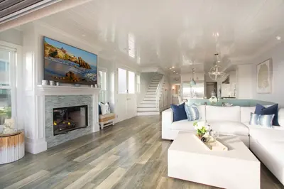 a living room with white furniture and a fireplace at Newport Beach Oceanfront Home in Newport Beach