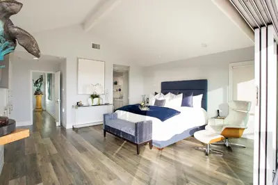 a bedroom with a large bed and a chair at Newport Beach Oceanfront Home in Newport Beach